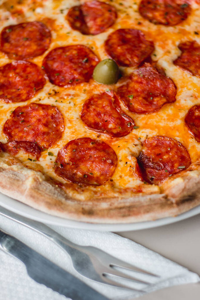 Close up de uma pizza com garfo e faca
 - Foto, Imagem