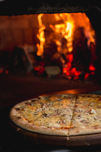 Foto de deliciosa pizza fresca diretamente do local do fogo
 - Foto, Imagem