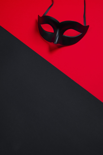 Sexy zwart masker op zwarte en rode achtergrond - Foto, afbeelding