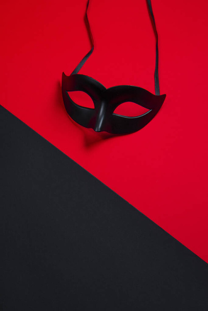 Σέξι μαύρη μάσκα σε μαύρο και κόκκινο φόντο - Φωτογραφία, εικόνα