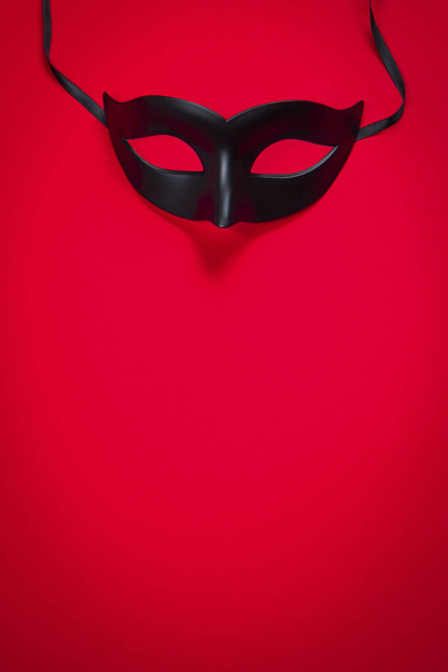 Σέξι μαύρη μάσκα σε κόκκινο φόντο - Φωτογραφία, εικόνα