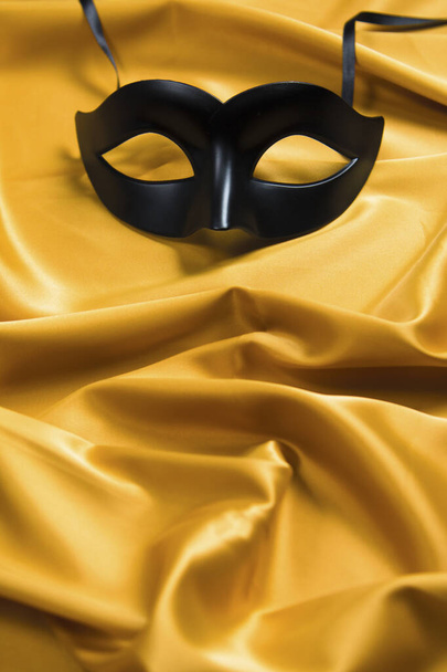 Sexy black mask on a yellow silk background - Photo, Image