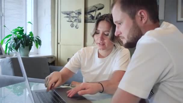 Stay home. Beautiful couple at home. Man work at home, he is in freelance during quarantine coronavirus, he use laptop. - Materiał filmowy, wideo
