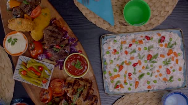 обідній стіл з картоплею та кетчупом, соуси майонезу, смачне м'ясо на грилі, російський салат, смачні м'ясні кульки, одягнені в цибулю, приправи та петрушку крупним планом
 - Кадри, відео