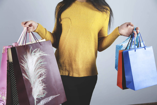 woman hand holding shopping bag on gray background - Photo, image