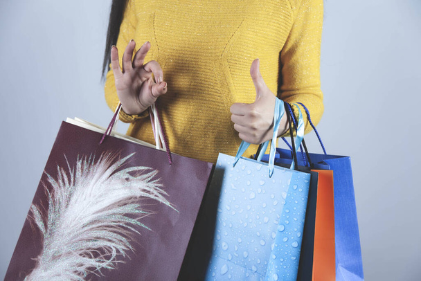 woman hand holding shopping bag on gray background - Foto, imagen