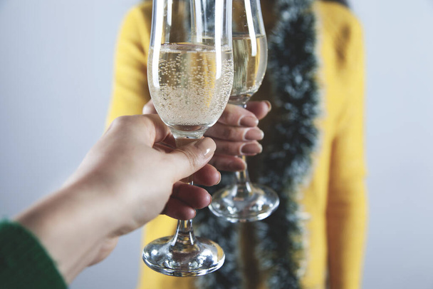 womans hands  champagne glasses on gray wall background - Photo, Image