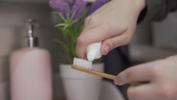 Primer plano de la mujer pone pasta de dientes en el cepillo de dientes
 - Imágenes, Vídeo