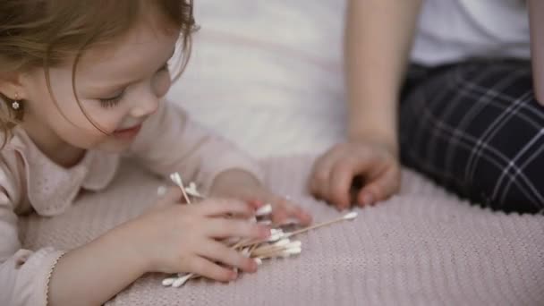 Close up of little girl plays with cotton swabs - Footage, Video