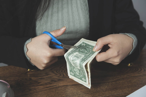 woman hand scissors with money on desk - Zdjęcie, obraz