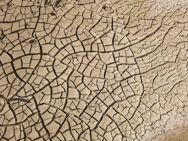 Overhead top view of dry arid soil with cracks during intense heat. Lack of water on agriculture field. Concept of global warming. - Photo, Image