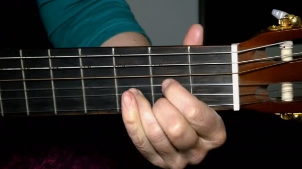 Пальці людської руки грають на акустичній дерев'яній гітарі, пальці роблять акорди
. - Кадри, відео