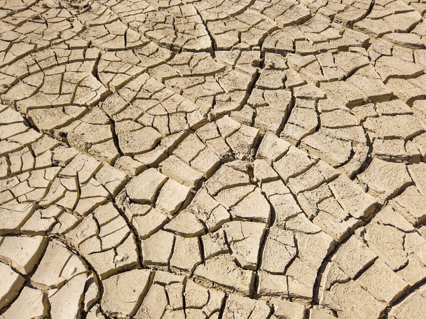 Вид сверху на сухую засушливую почву с трещинами во время сильной жары. Недостаток воды в сельском хозяйстве. Концепция глобального потепления. - Фото, изображение