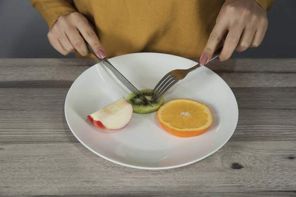 woman  handorange and apple on  plate on desk - 写真・画像