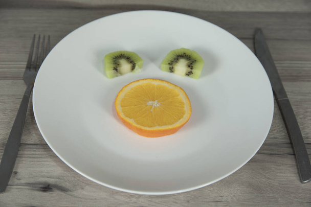  kiwi orange on the white plate on table - Photo, Image
