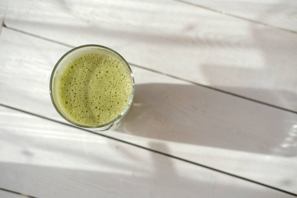 matcha oatmilk in a glass. healthy drinks concept. modern fashionable drink for weight loss and energy boost. alternative non dairy product. top view - Photo, Image