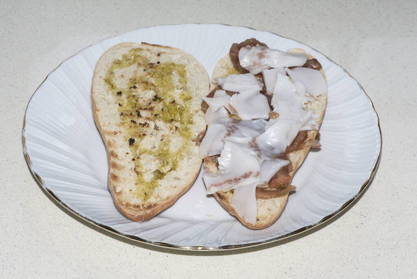 Maaseudun aamiainen puu leipää paahtoleipää oliiviöljyn tomaatti ja ohuita viipaleita Iberian pekonia valoa flash
 - Valokuva, kuva