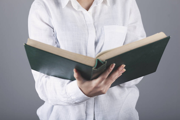 woman hand book   on gray background - Фото, изображение