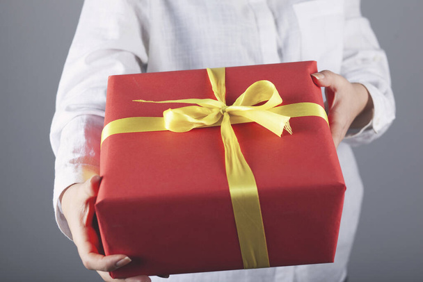 woman hand beautiful gift box in face  - Фото, изображение