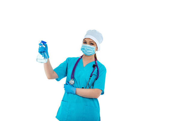 制服を着た女性医師や看護師は消毒スプレーを使用します。消毒だ。ウイルスや細菌からの保護。美しい女医は消毒スプレーを持っています。白い背景に隔離された - 写真・画像