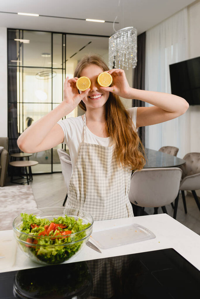 Koken meisje maken plezier met citroen helften - Foto, afbeelding