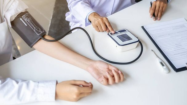 Doktor měří krevní tlak pacienta na klinice nebo v nemocniční ordinaci. Zdravotní a zdravotní koncepce. - Fotografie, Obrázek
