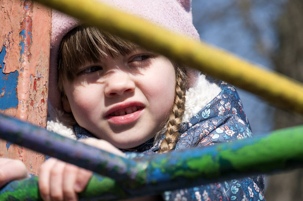 Küçük bir kızın portresi Bir merdivenin demir parmaklıklarında - Fotoğraf, Görsel