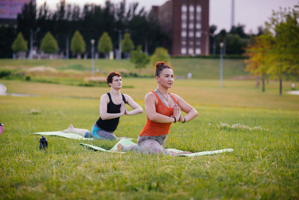 Young girls do yoga outdoors in the Park during sunset. Healthy lifestyle - Foto, immagini
