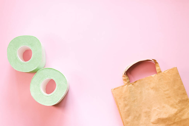 Toilet paper rolls and a craft bag on a pink background top view, selective focus. - 写真・画像