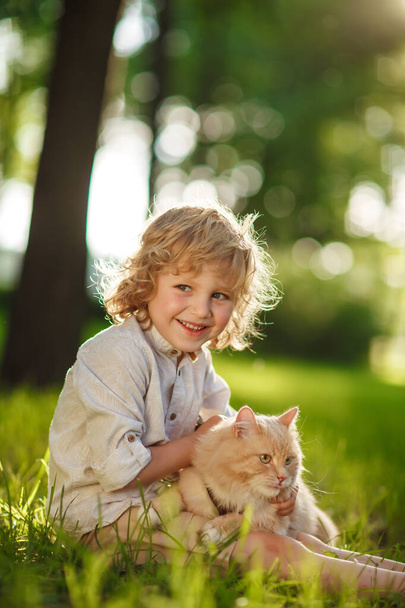 Маленький кудрявый мальчик с рыжей кошкой
 - Фото, изображение