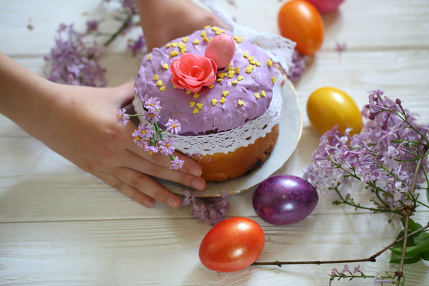 Children's hands hold Easter cake in sugar icing - Foto, imagen