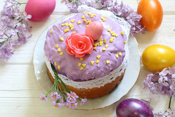 Easter cake, colored eggs and a bouquet of lilacs - Fotoğraf, Görsel