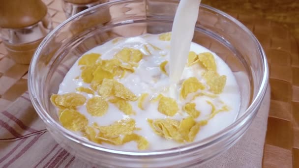 Crispy yellow corn flakes into the bowl for the morning a delicious Breakfast with milk. Slow motion with rotation tracking shot. - Séquence, vidéo