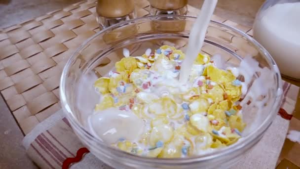 Crispy yellow corn flakes into the bowl for the morning a delicious Breakfast with milk. Slow motion with rotation tracking shot. - Materiał filmowy, wideo