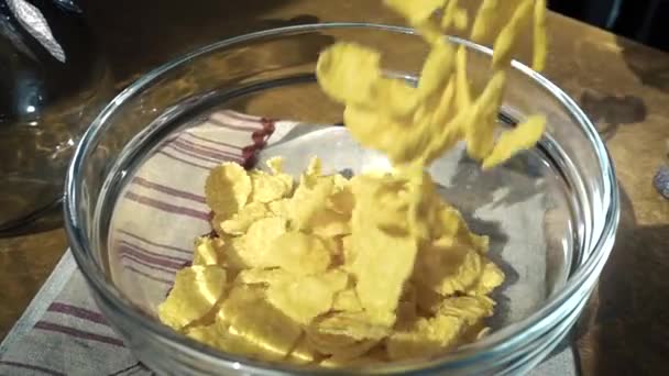 Crispy yellow corn flakes into the bowl for the morning a delicious Breakfast with milk. Slow motion with rotation tracking shot. - Imágenes, Vídeo