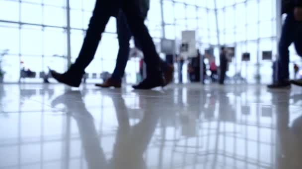 People out of focus walk inside a bright, modern building. Focus in the foreground - Footage, Video