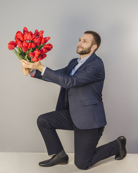 a young man with red flowers - Foto, Imagen