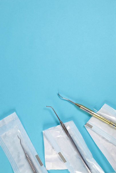 Strumenti dentali in pacchetti artigianali su sfondo blu
. - Foto, immagini