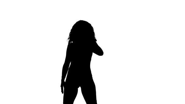černá silueta na bílém pozadí, mladá krásná dívka provádějící energický tanec, street dance, latinský tanec, střední střela  - Záběry, video