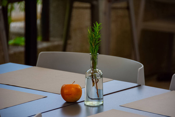 Красиво украшенный стол с яблоком и сосновой ветвью в ресторане в Любляне
 - Фото, изображение
