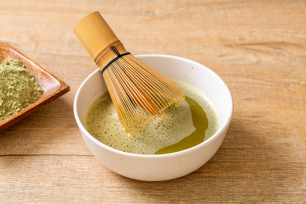hot matcha green tea cup with green tea powder and bamboo whisk - Φωτογραφία, εικόνα