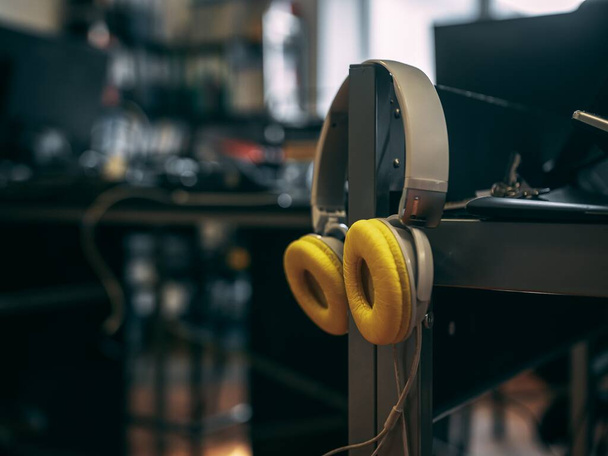 A closeup shot of headphones on the side of a desk - Fotó, kép