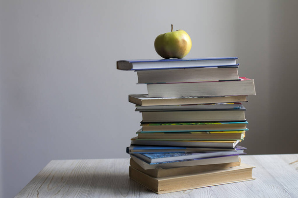 Egy halom könyv egy almával a tetején. Coronovírus Online tanulás - Fotó, kép