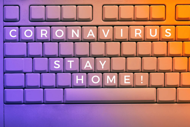 Text "Stay home" on keys of keyboard, close-up on electronic computer keyboard with warning message for people to slow down spreading of coronavirus across the globe. Image toned in orange and purple. - Fotografie, Obrázek