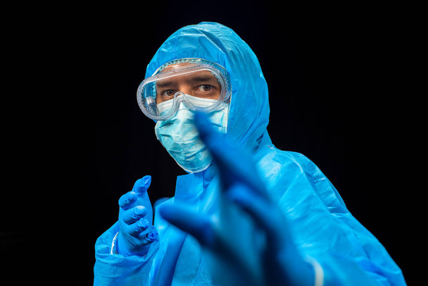 The fight against the virus. A man in a protective antivirus suit. - Foto, Bild