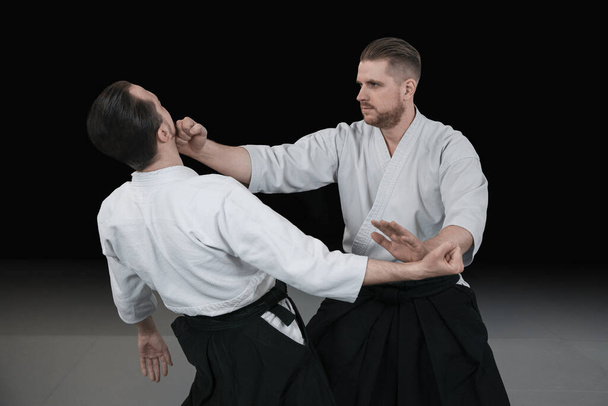 Two martial arts fighters practice aikido techniques at the dojo - Photo, Image