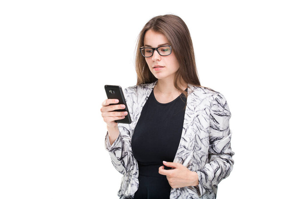 Jeune femme d'affaires regardant le téléphone portable isolé sur fond blanc. Joyeux jeune femme tenant un téléphone intelligent, en utilisant l'application et la technologie smartphone. concept commercial et technologique
. - Photo, image