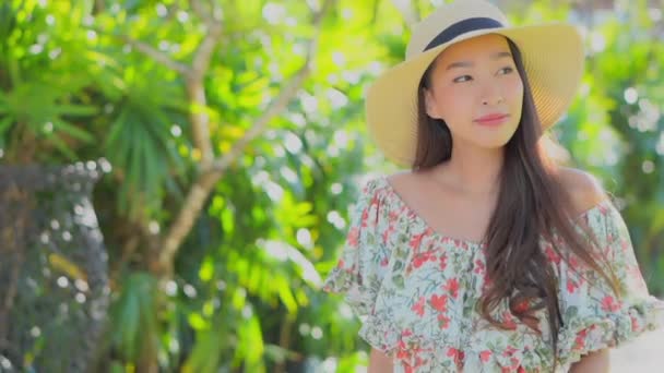 metraje de hermosa joven asiática mujer caminando en verde jardín - Imágenes, Vídeo