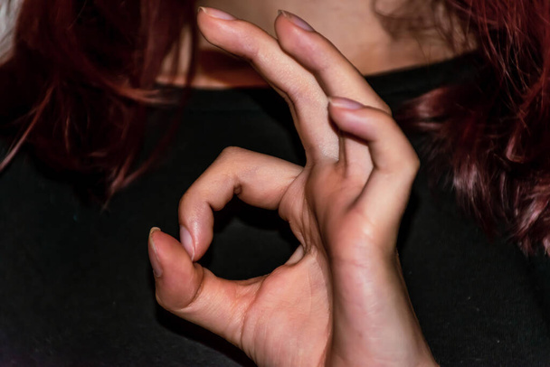 Een close-up van een onherkenbare jonge blanke vrouw 's hand die het' ok '/' okay 'gebaar maakt - Foto, afbeelding