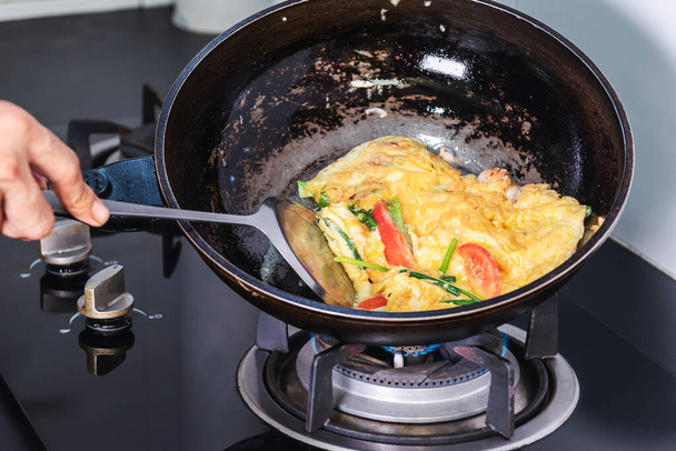 Kızartma tavasında yumurta kızartmak. Mutfaktaki gaz sobasının ısısıyla.. - Fotoğraf, Görsel